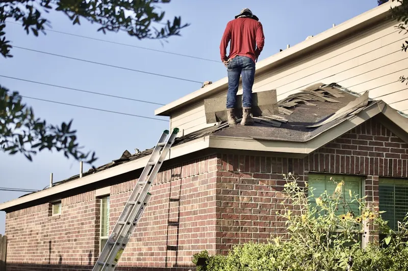 Professional roofer working on a residential roof in Manchester Square